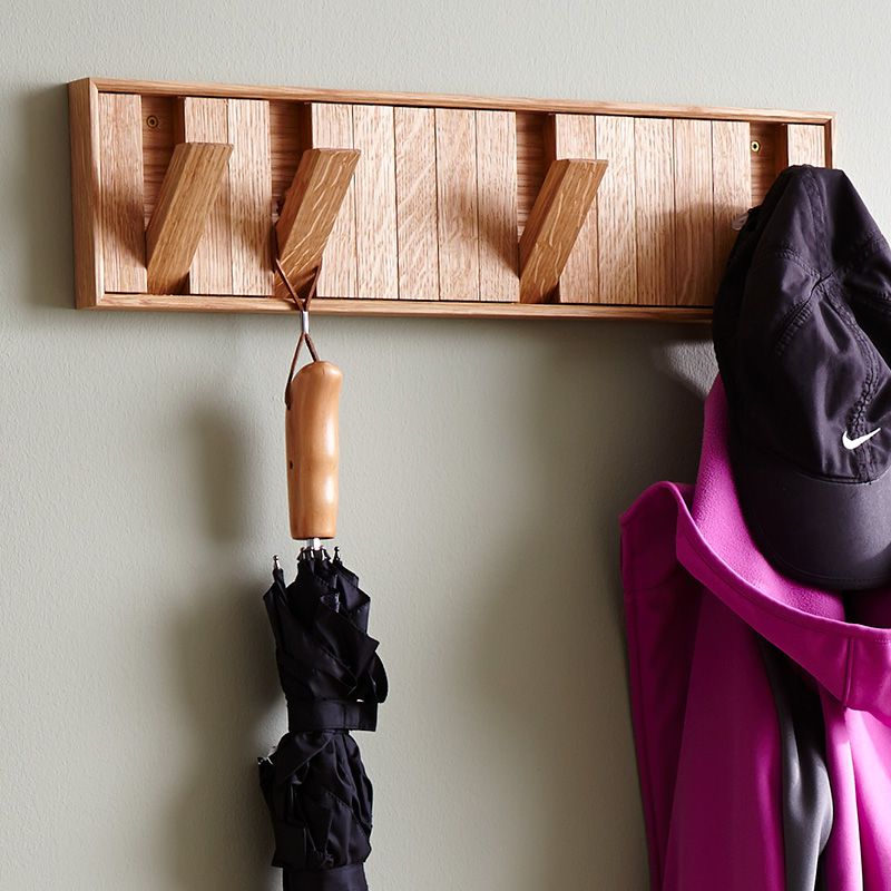 Wall-hung coat rack with hooks that rotate to hide away