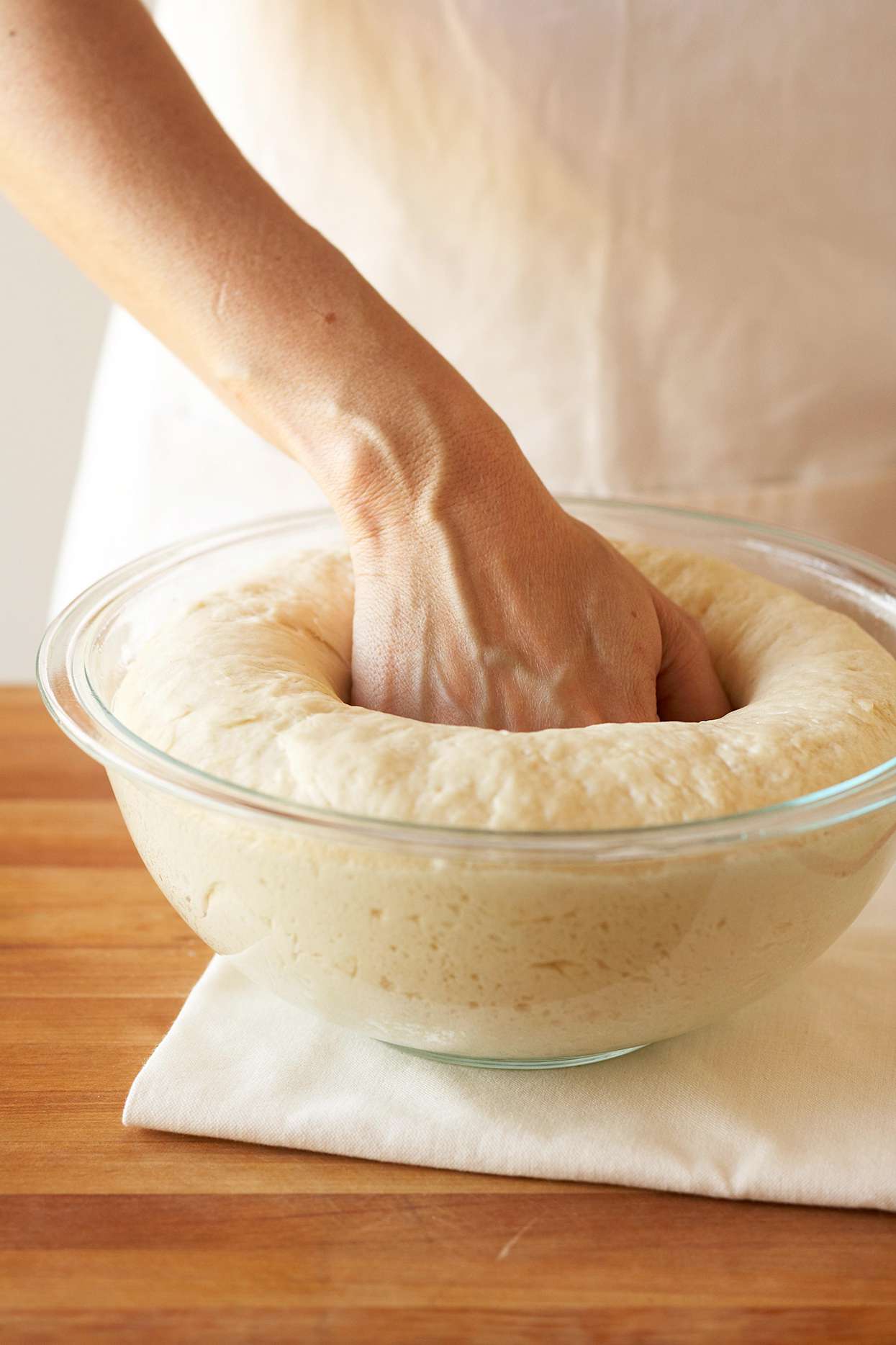 Punch down dough for cinnamon rolls