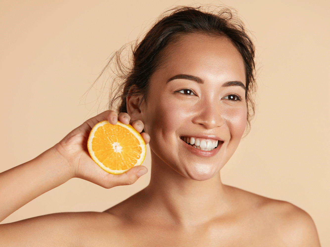 vitamin-c-for-skin: woman squeezing orange