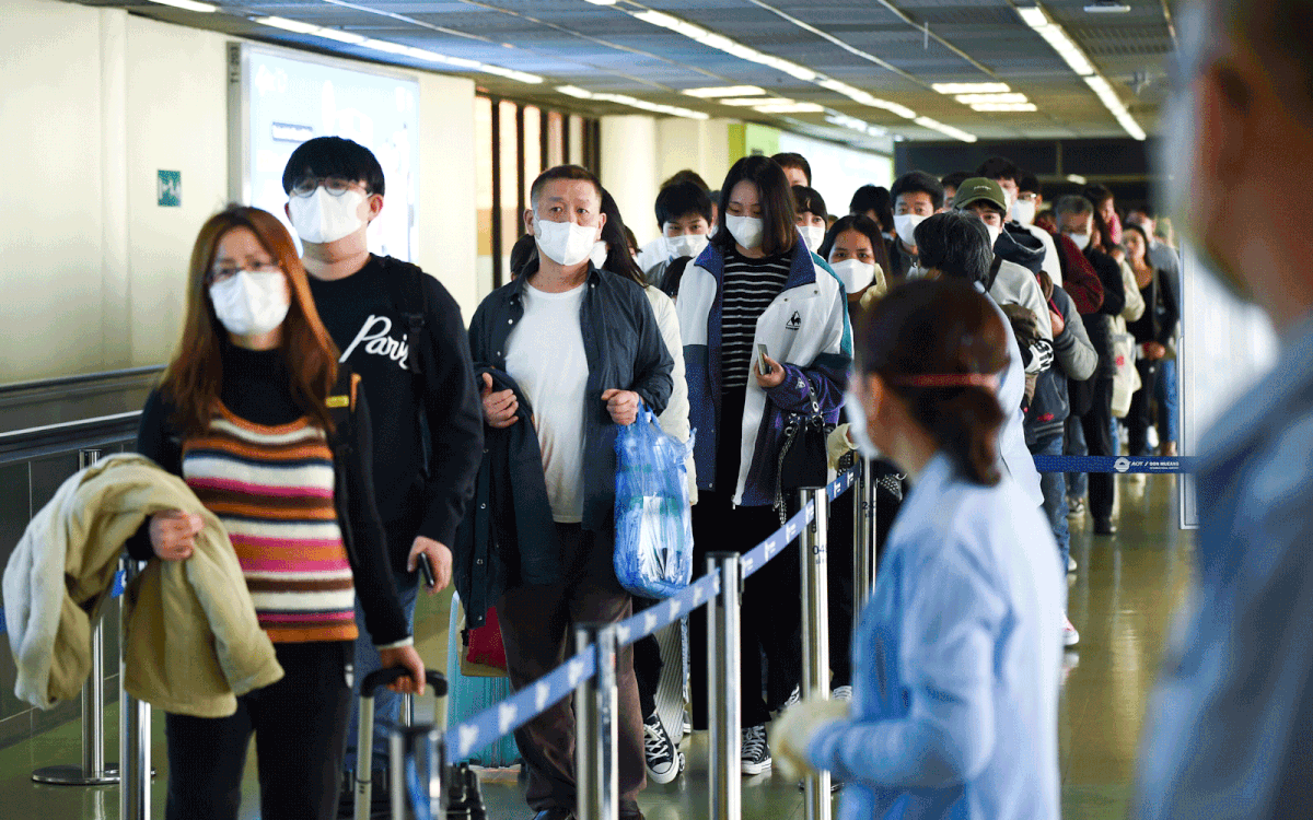 Tourists wear masks at Don Mueang Airport, in Bangkok, Thailand.