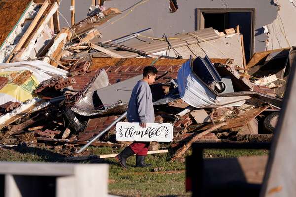 Mandatory Credit: Photo by LM Otero/AP/Shutterstock (13609768h) Logan Johnson, 11, carries a sign that reads "Thankful" after he recovered it from his family's destroyed home after a tornado hit in Powderly, Texas Severe Weather Texas, Powderly, United States - 05 Nov 2022