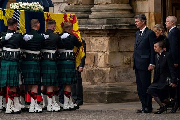 TOPSHOT - Vice Admiral Timothy Laurence (4R), Britain's Sophie, Countess of Wessex (2R) and Britain's Prince Andrew, Duke of York (R) stands as Britain's Princess Anne, the Princess Royal curtseys to the coffin of Queen Elizabeth II, draped with the Royal Standard of Scotland, as it is carried in to the Palace of Holyroodhouse, in Edinburgh on September 11, 2022. - The coffin carrying the body of Queen Elizabeth II left her beloved Balmoral Castle on Sunday, beginning a six-hour journey to the Scottish capital of Edinburgh. (Photo by Aaron Chown / POOL / AFP) (Photo by AARON CHOWN/POOL/AFP via Getty Images)