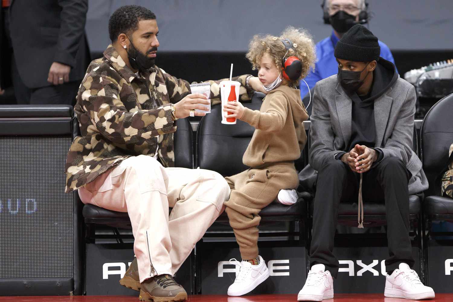 ドレイクと息子アドニス, 4, NBAゲームでコートサイドに座って乾杯ドリンク—かわいい写真を​​参照してください