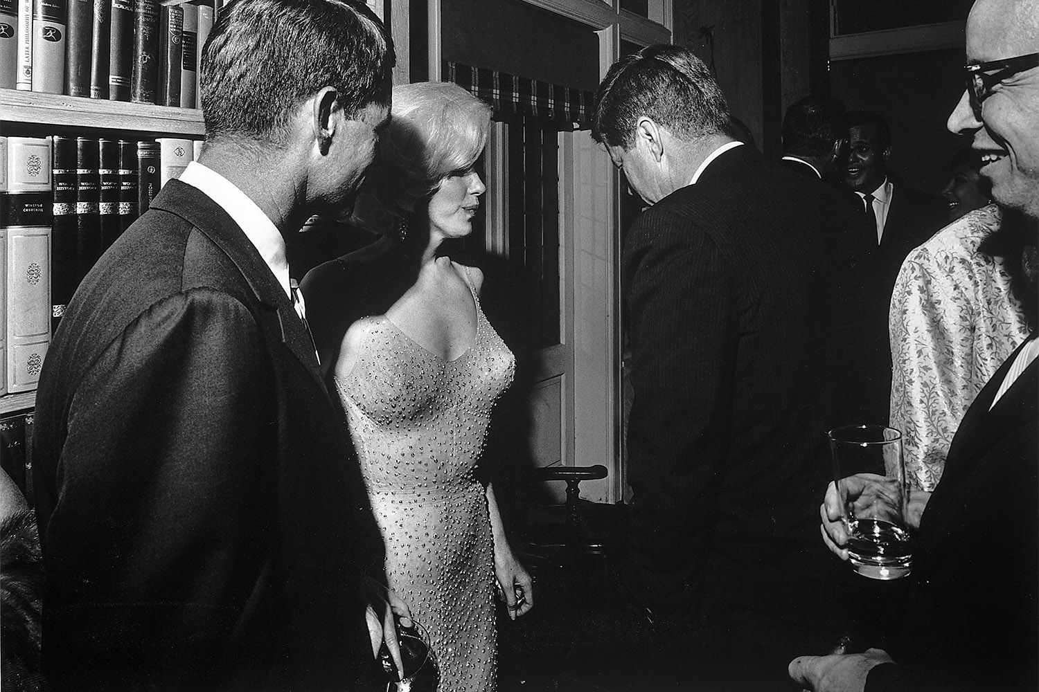 During a party at the home of movie executive Arthur Krim, American actress Marilyn Monroe stands between Robert Kennedy (left) and John F. Kennedy, New York, New York, May 19, 1962. The party followed a democratic fundraiser at Madison Square Garden honoring John F. Kennedy's birthday where Monroe famously sang "Happy Birthday.' (Photo by Cecil Stoughton/The LIFE Images Collection via Getty Images/Getty Images)