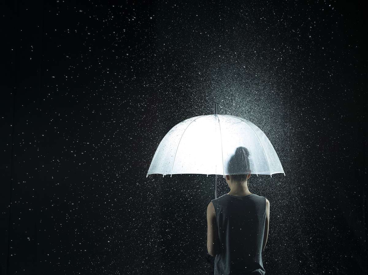 Back of a woman under a see-through umbrella