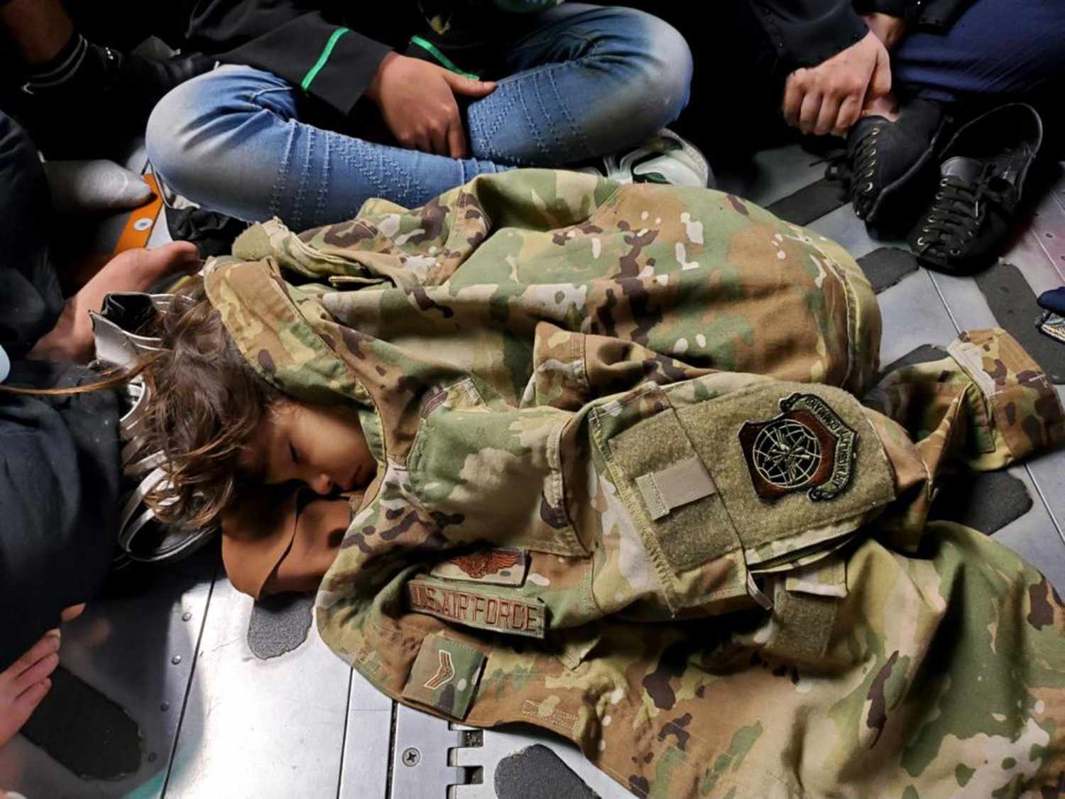 The Story Behind Moving Photo of Child Sleeping on Afghanistan Escape Plane Under Airman's Uniform