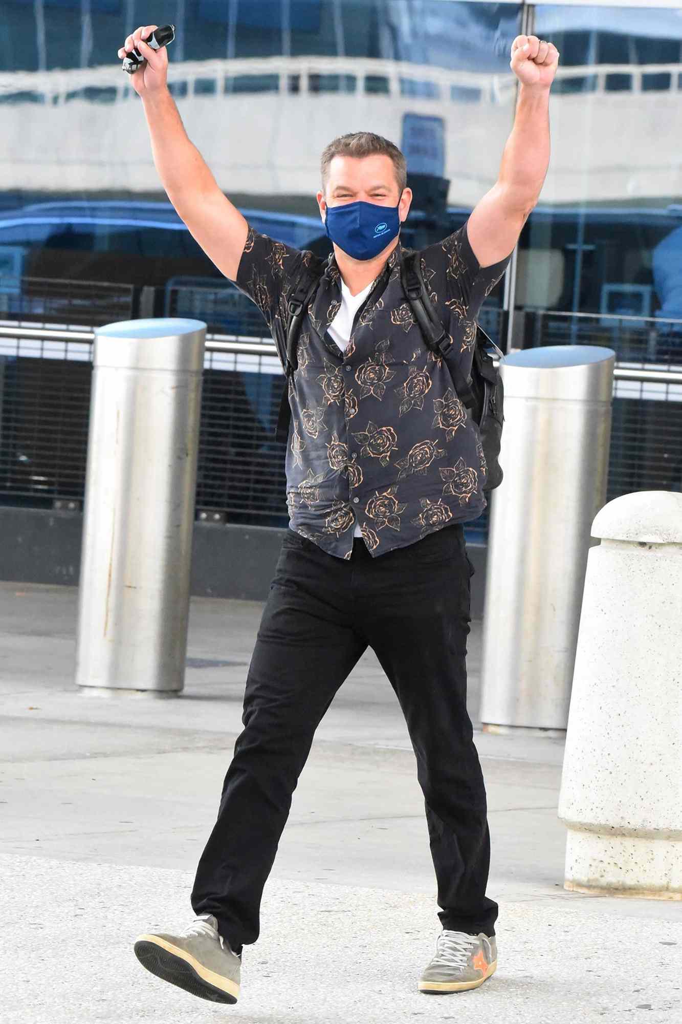 Matt Damon raises his arms triumphantly in NYC