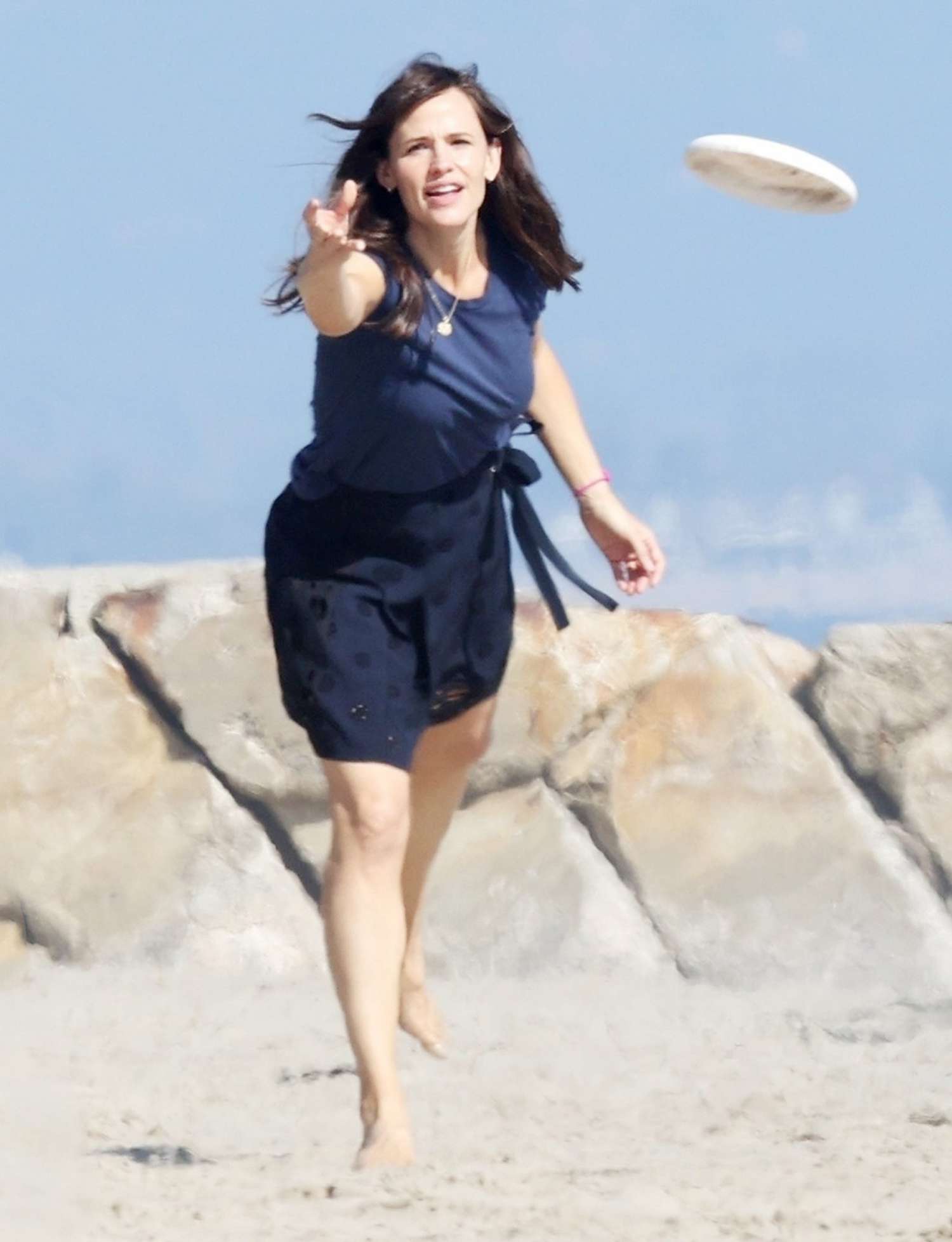 Jennifer Garner plays frisbee on the beach with a friend.