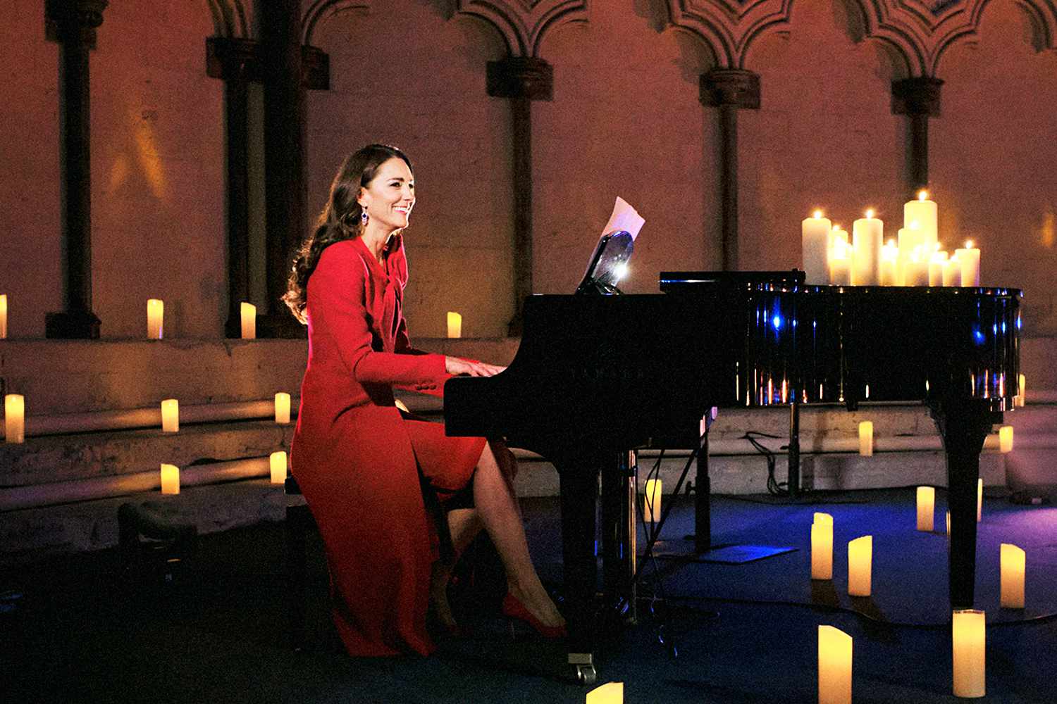In this image released December 24, 2021, Catherine, Duchess of Cambridge accompanies singer Tom Walker on the piano during a performance of his song 'For Those Who Can't Be Here' during Royal Carols - Together At Christmas, a Christmas carol concert hosted by the Duchess of Cambridge at Westminster Abbey in London on December 8, which was broadcast on Christmas Eve 2021.