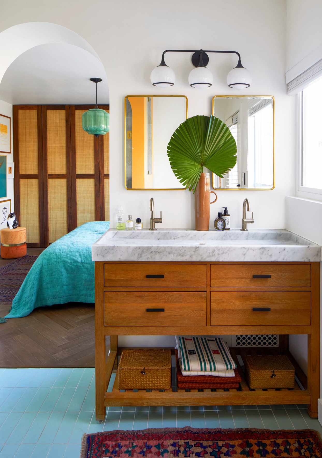 bathroom with wooden vanity and rounded arch into bedroom