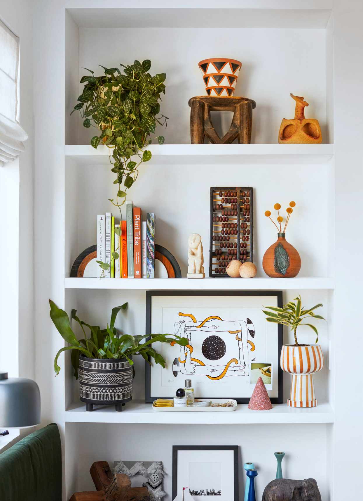 white shelf with plants, books, and decorations