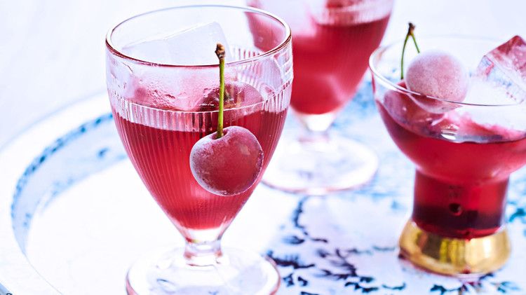 cherry bounce cocktail garnished with frozen cherries