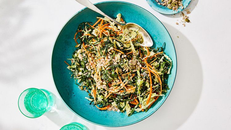 cilantro-lime kale slaw with seeds served in a blue bowl