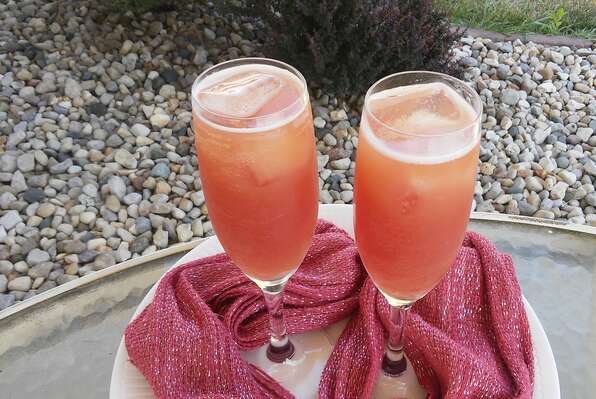 Two champagne flutes of pink mocktails