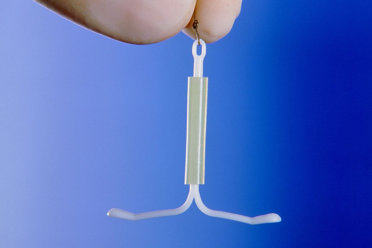 Newborn Baby Photographed with Mother's IUD in Hand