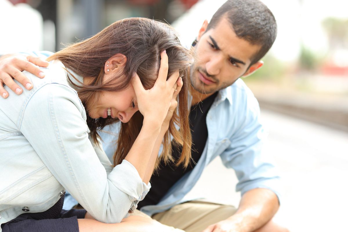 Stressed, anxious woman having a panic attack being comforted by man