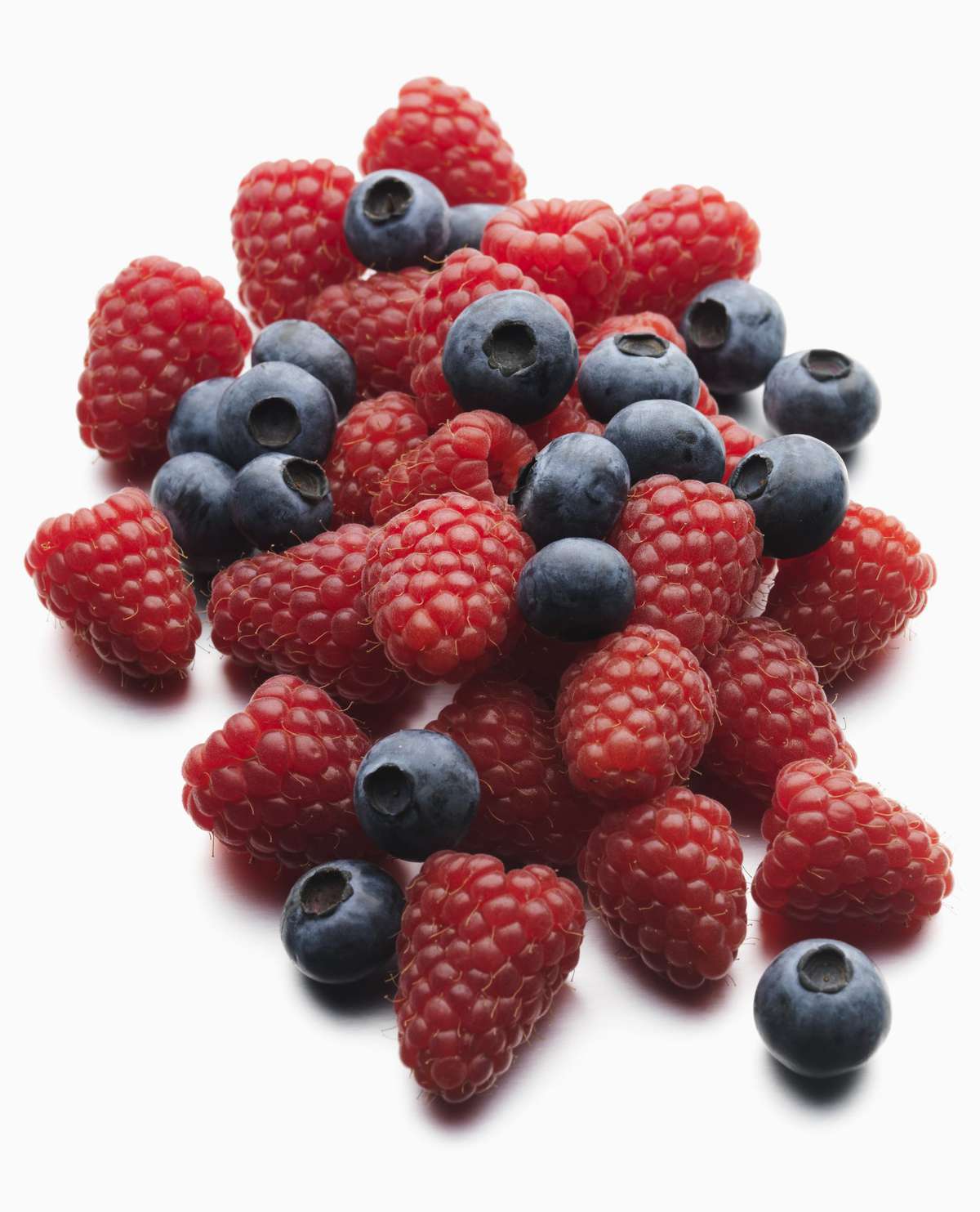 A pile of fresh raspberries and blueberries on a white background