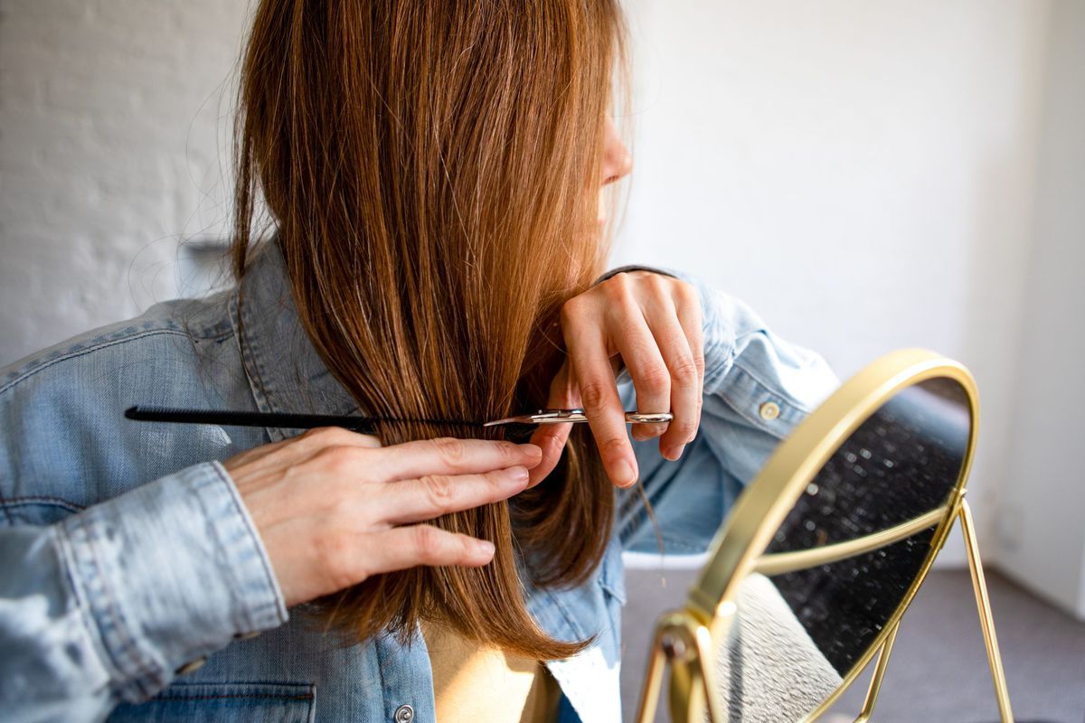 A woman cutting her own hair