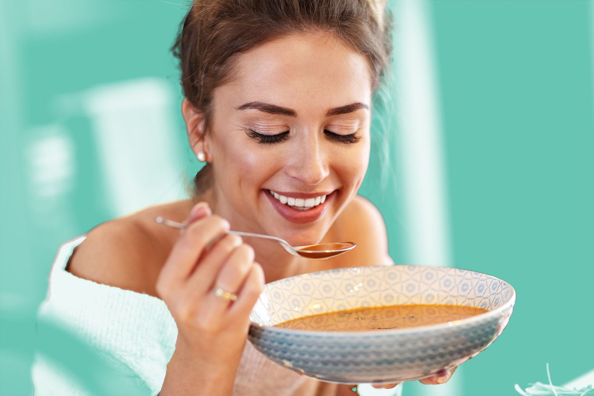 Adult woman eating pumpkin soup in the kitchen. prolon-diet , intermittent-fasting