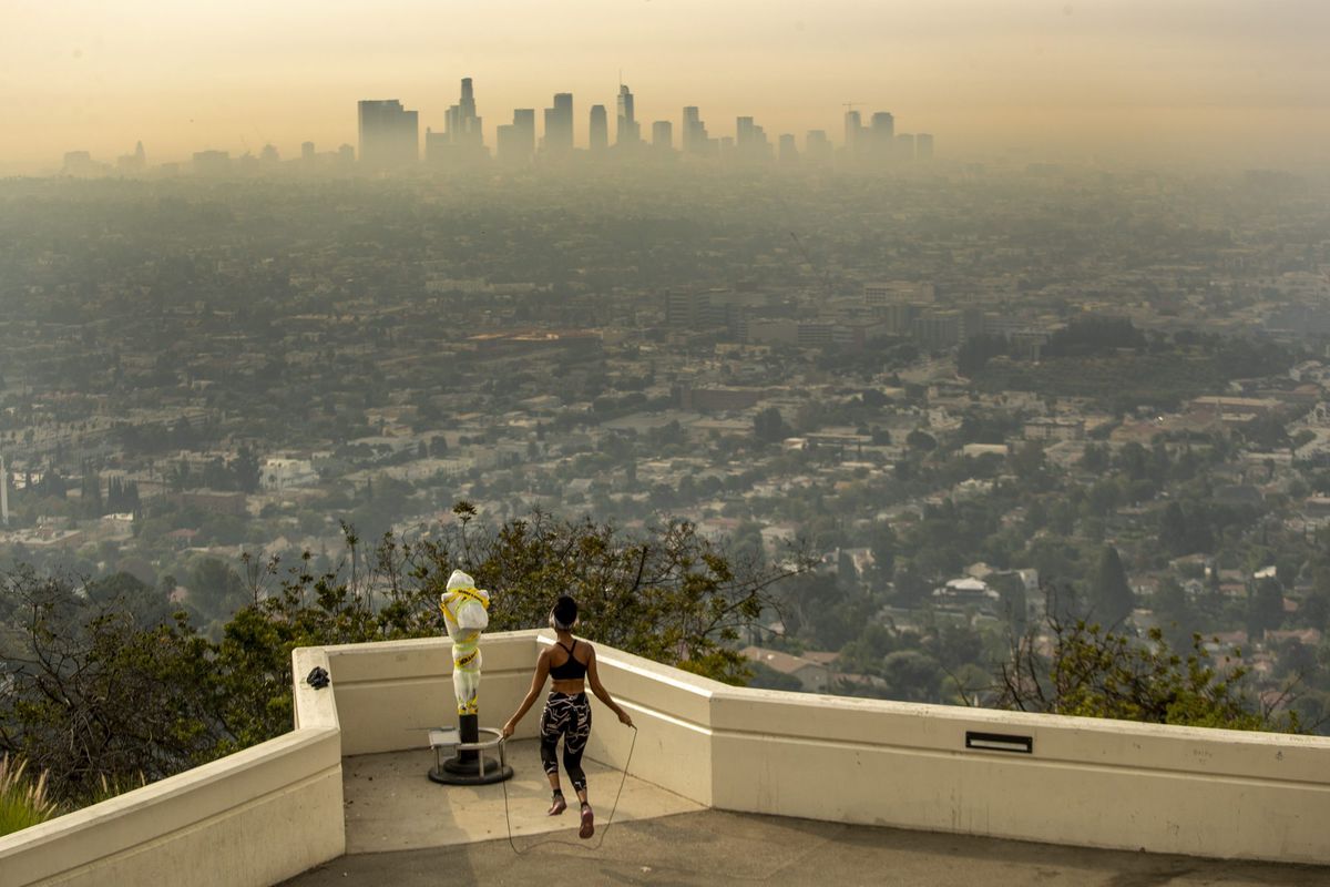 bad-air-quality-workout-exercise , LOS ANGELES, CA - SEPTEMBER 17: Los Angeles resident Carmen Green jumps rope at a closed Griffith Observatory where she found a quiet nook to exercise in spite of dense smoke from Southern California wildfires choking the L.A. Basin on Thursday, Sept. 17, 2020 in Los Angeles, CA. (Brian van der Brug / Los Angeles Times via Getty Images)