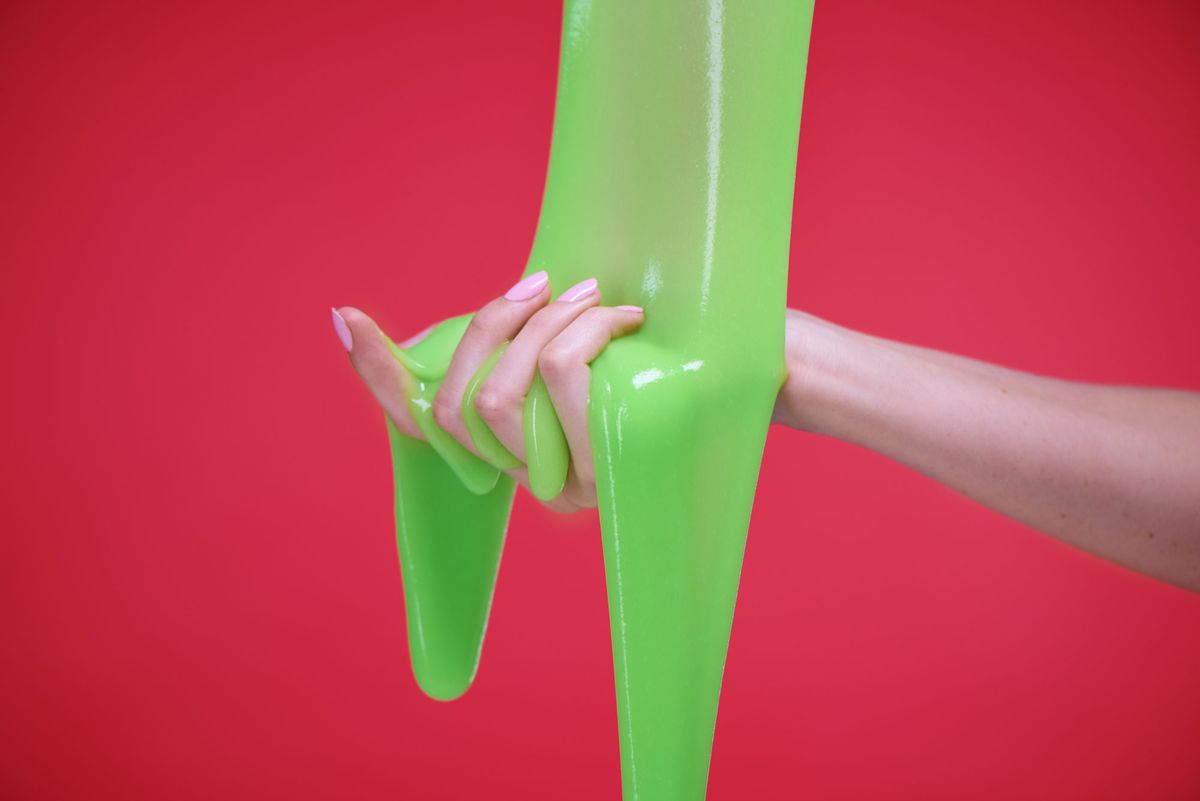 hand with slime on red background