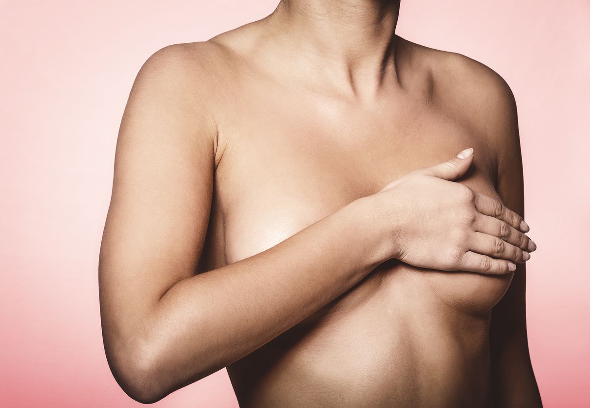 女人半身像的喜悦的观点被手覆盖。乳腺癌的概念。