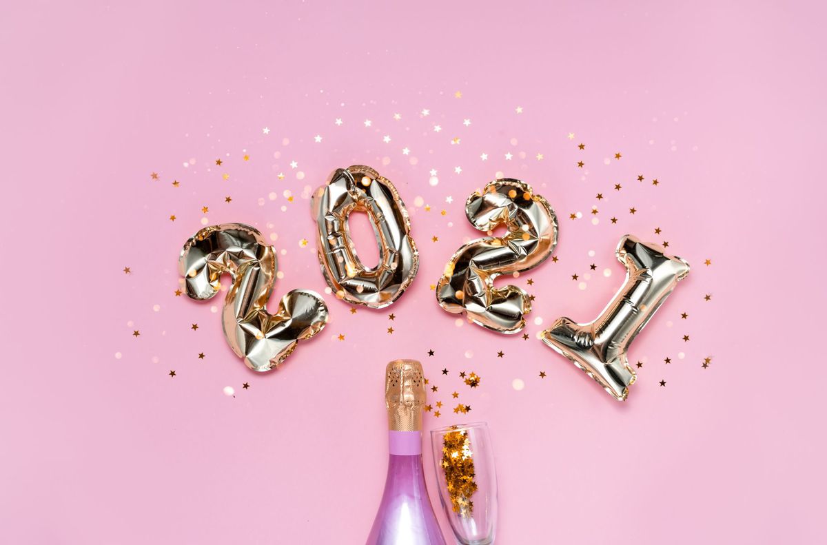 2021 golden foil balloons numbers, champagne, stars confetti, ribbons and bokeh. Top horizontal view copy space new year and holiday concept.