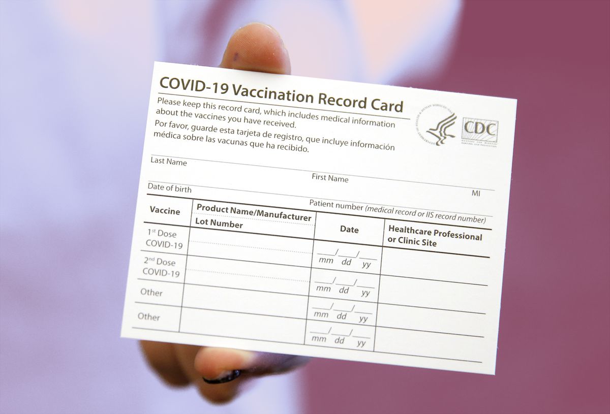 Your COVID-19 Vaccine Card, What to Do if You Lose It, Why You Shouldn't Laminate It, and Other Important Info , BOSTON - DECEMBER 16: Elizabeth Hafted, Pharmacist displays a COVID-19 Vaccination Record Card at Beth Israel Deaconess Medical Center in Boston on Dec. 16, 2020. (Photo by Jessica Rinaldi/The Boston Globe via Getty Images)