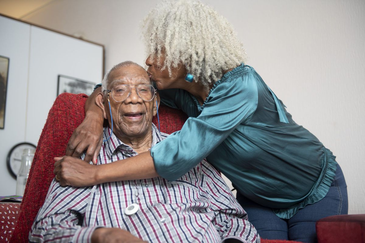 Care.com-Senior woman giving her 91 year old father a kiss on the head