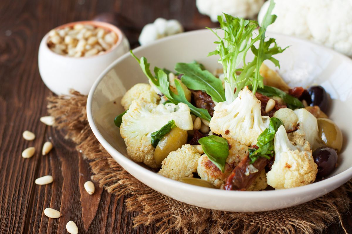 Roasted cauliflower salad with olives, tomatoes, nuts and basil-GettyImages-950928638