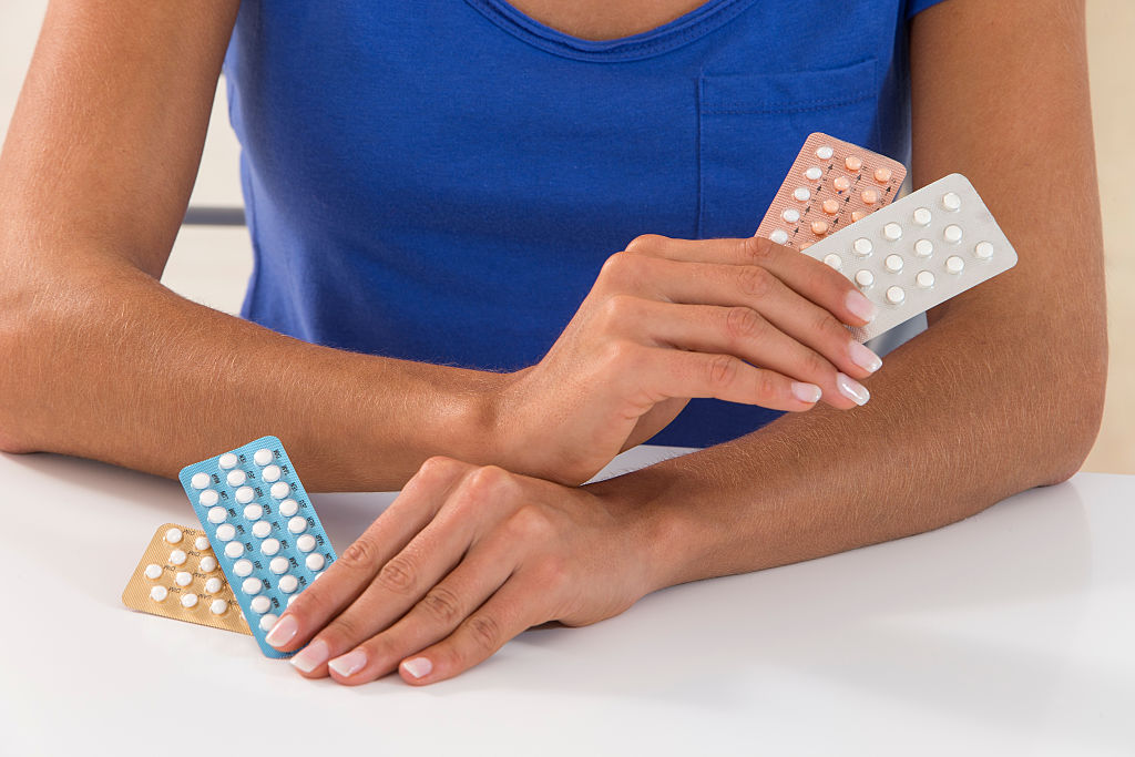 Woman holding birth control pills.