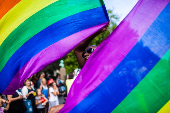 A gay parade participant is waving the rainbow flag, which has become a strong symbol for the worldwide LGBT community. Denmark 2013.