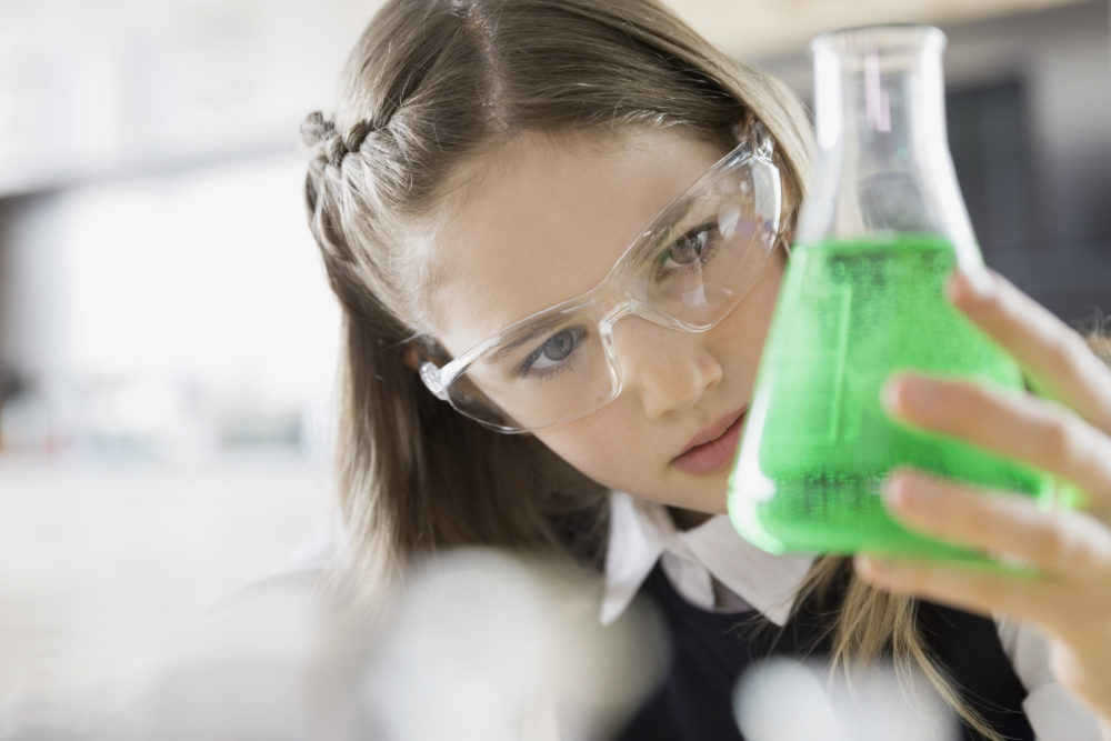 School girl examining liquid in beaker