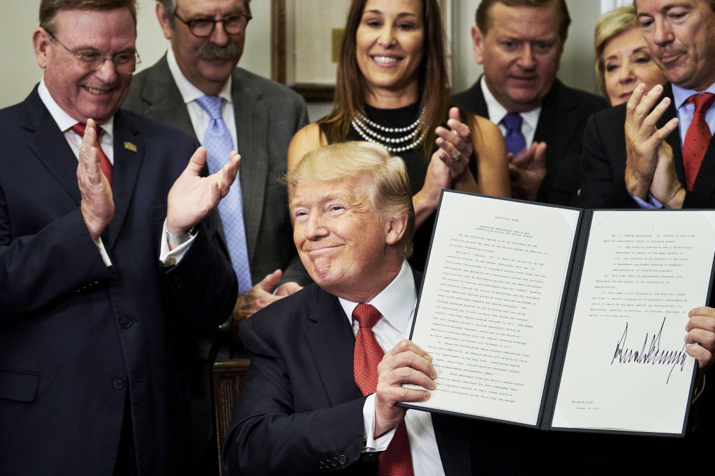 U.S. President Donald Trump holds up a signed executive order on health care in the Roosevelt Room of the White House in Washington, D.C., U.S., on Thursday, Oct. 12, 2017. Trump signed an executive order Thursday designed to expand health insurance options for some Americans, in a move that may also undermine coverage for those who remain in Obamacare. Photographer: T.J. Kirkpatrick/Bloomberg via Getty Images