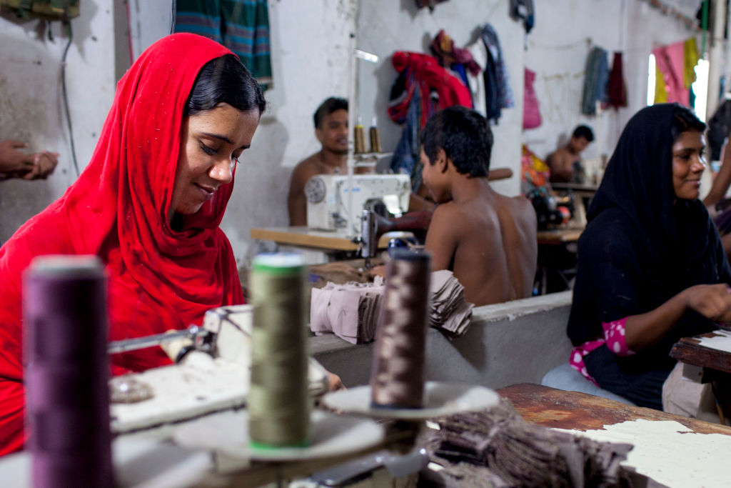 SADARGHAT, DHAKA, BANGLADESH - 2017/06/04: Farida sews a cloth in a local garment shop in Dhaka, Bangladesh. World Day Against Child Labor was observed on 12 June across the world to raise awareness and contribute to ending child labor. The theme of this year's 'No to Child Labor, Yes to Quality Education'. (Photo by K M Asad/LightRocket via Getty Images)