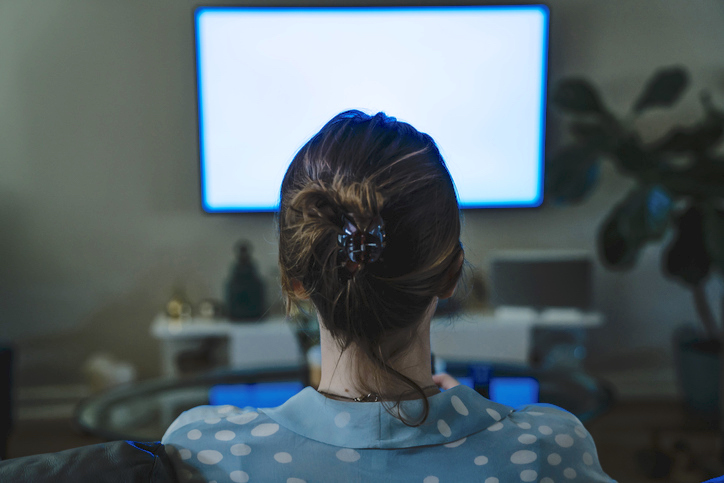 Back of woman's head watching TV