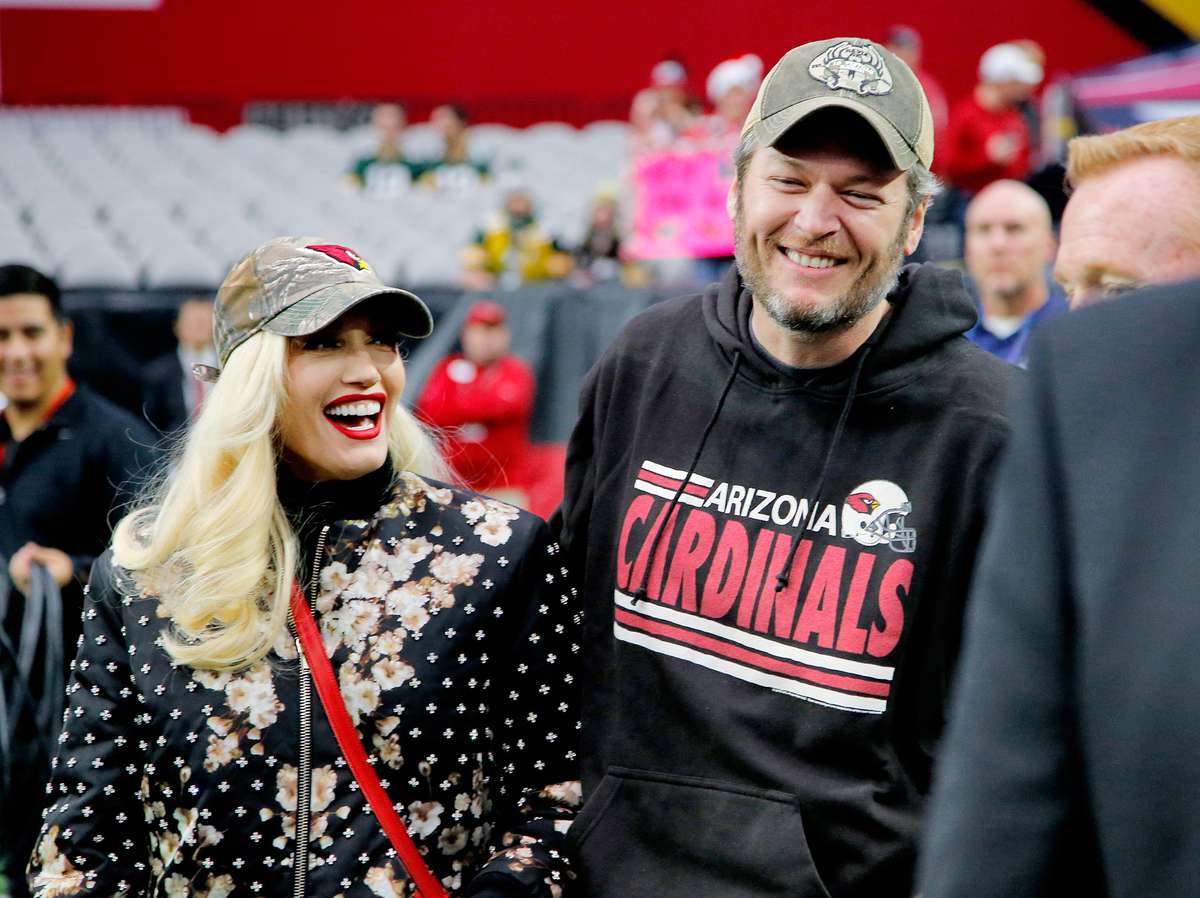Singers Gwen Stephani and Blake Shelton stand on the sidelines prior to an NFL football game between the Green Bay Packers and the Arizona Cardinals, Sunday, Dec. 27, 2015, in Glendale, Ariz.