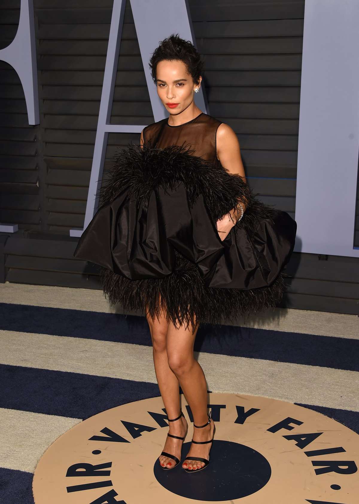 Zoe Kravitz wearing a short black dress with feather trimming