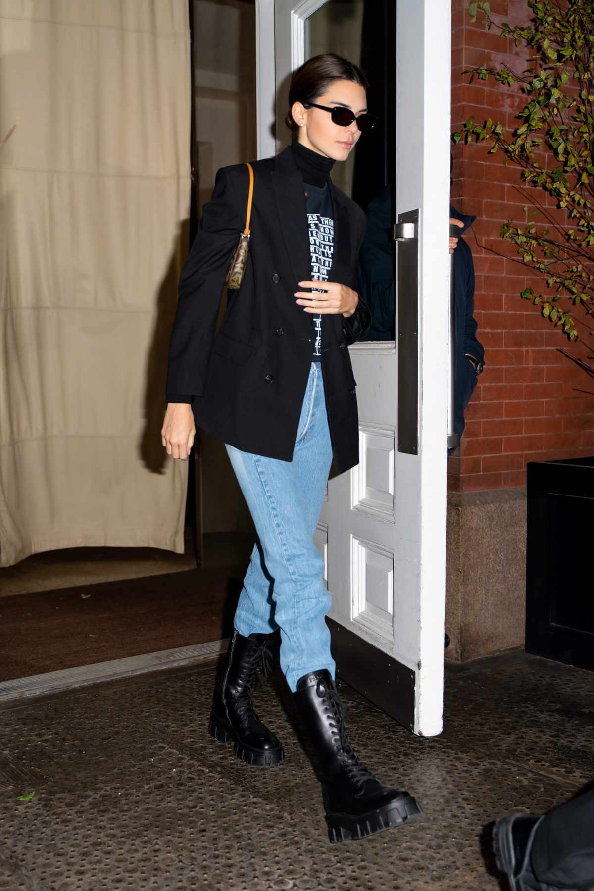 <p>Channeling major 90s Princess Diana vibes, Kendall was seen out in NYC sporting a structured black blazer over a similar-hued graphic tee and turtleneck. Her mom jeans loosely tucked into a pair of chunky combat boots, Jenner’s outfit rendered new-age business casual attire.</p>
                            