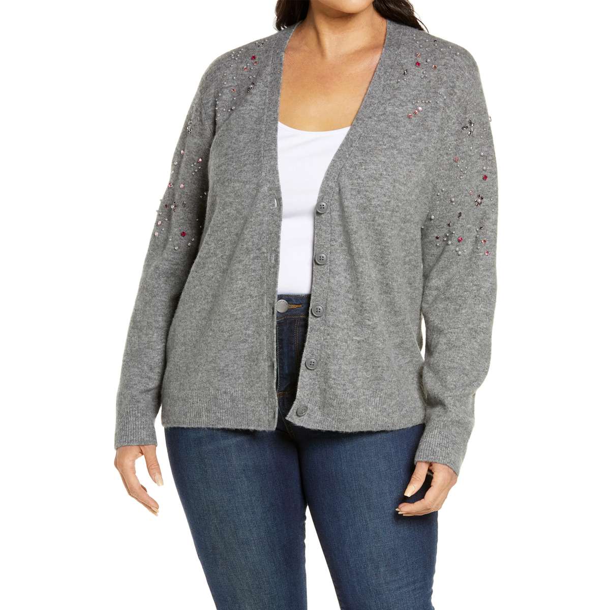plus-sized woman wearing gray button up sweater with rhinestones on upper half