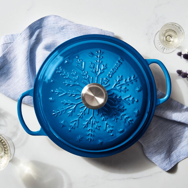 shallow blue Dutch oven with a snowflake-embossed lid