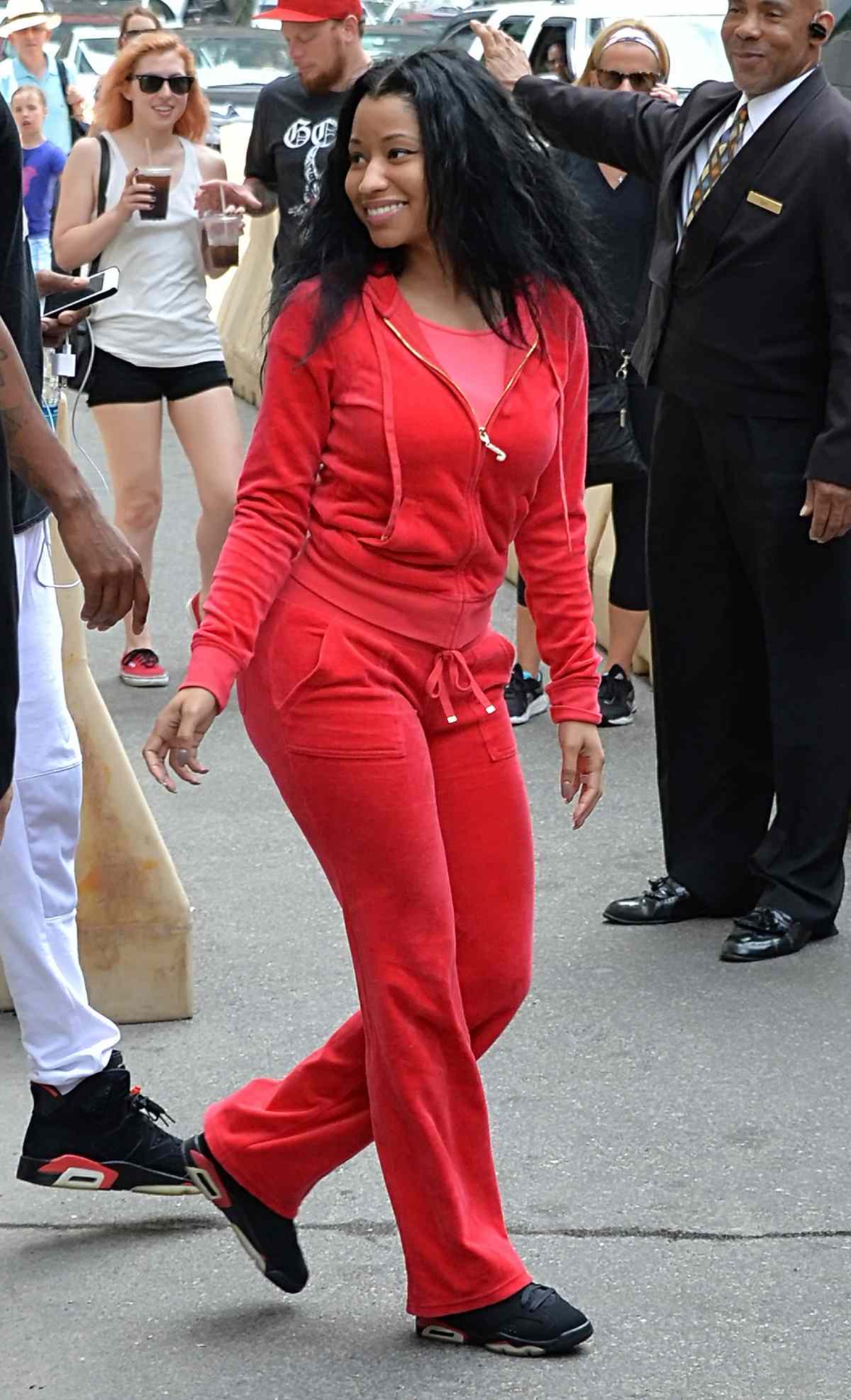 Nicki Minaj, dressed down in an all red Juicy tracksuit, leaves her hotel