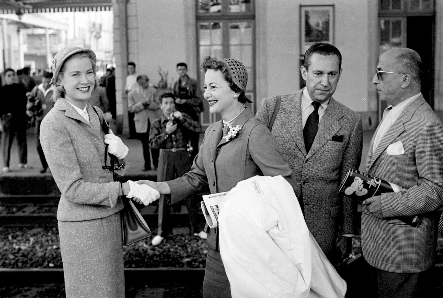 Olivia de Havilland and Grace Kelly, on right Pierre Galante. Arrival at Cannes station 1955 the first meeting of Princess Grace and Prince Rainier, please tool the attached photo. Caption info: Olivia de Havilland and Grace Kelly, on right Pierre Galante. Arrival at Cannes station 1955 (Pierre Galante is the man with the black tie. The other man's id is not known). Credit must read : "Photo Edward Quinn, &copy; edwardquinn.com&rdquo;