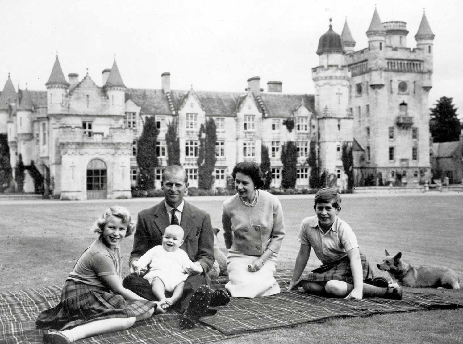 Royalty. 9th September 1960. During their holiday on the Balmoral Castle estate the Royal family sit together within the grounds, a happy smiling baby Prince Andrew held on his father the Duke of Edinburgh+s lap. Pictured also smiling is Queen Elizabeth I