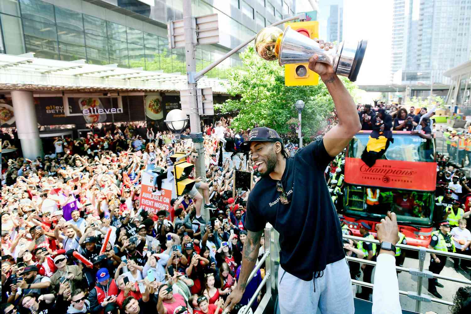 Toronto Raptors forward Kawhi Leonard hoists his playoffs MVP trophy during the NBA basketball championship team's victory parade in Toronto, Monday, June 17, 2019