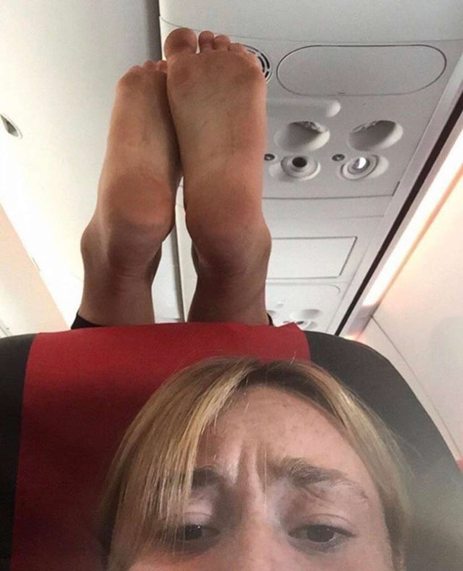 Plane passenger puts feet on headrest