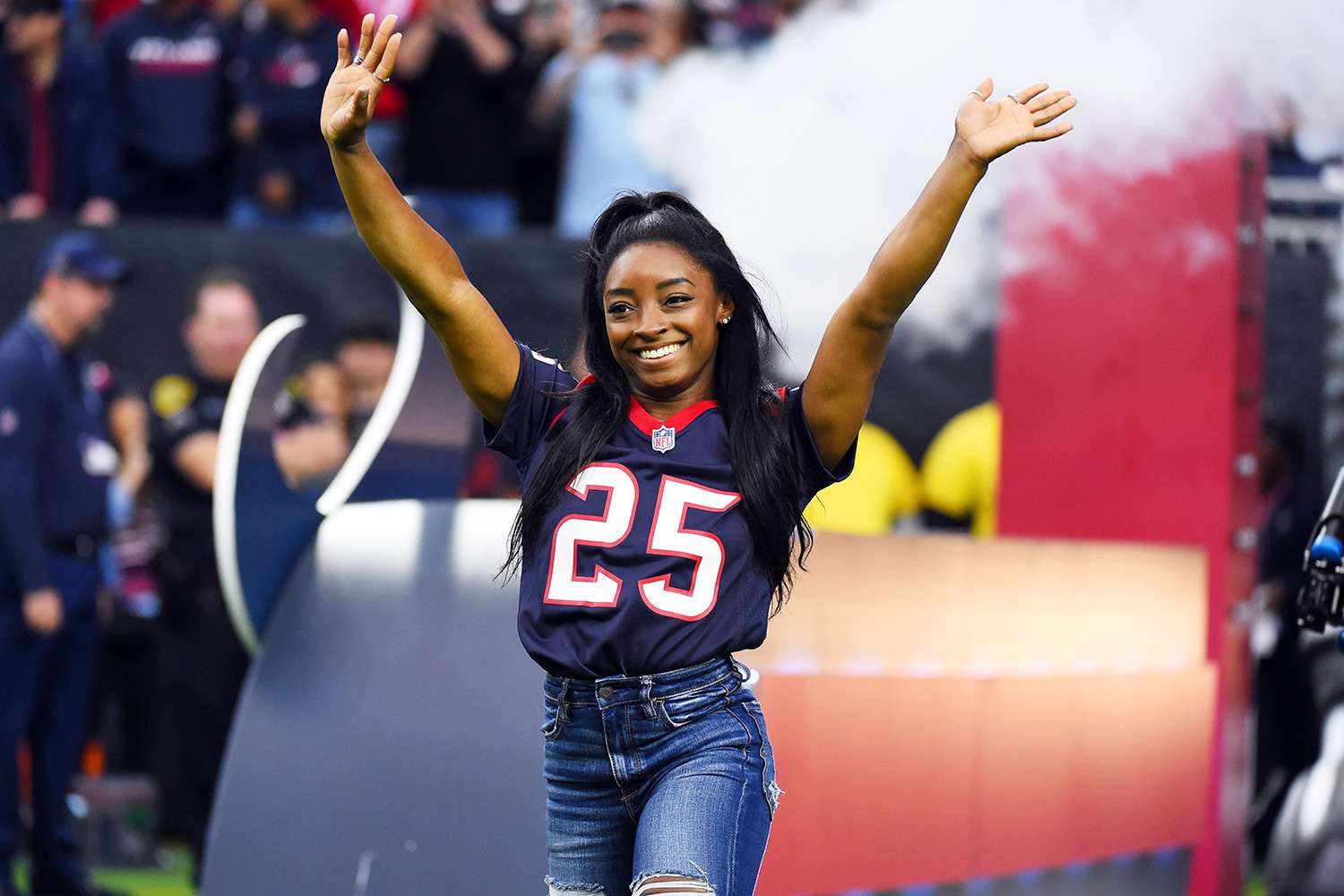 Olympic gymnast Simone Biles leads the Houston Texans out to the field as the homefield advantage captain before an NFL football game against the Tennessee Titans, in Houston