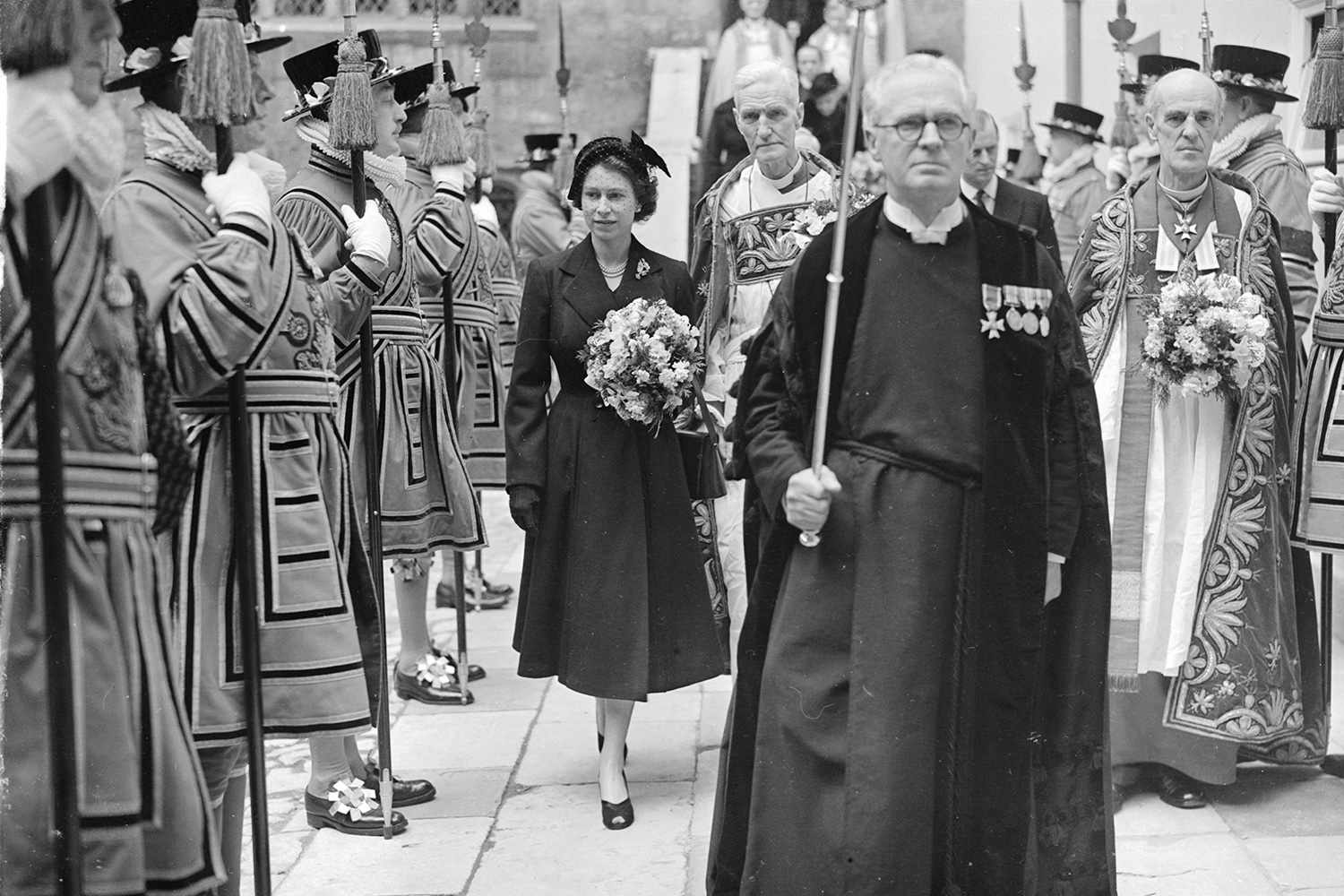 10th April 1952: Queen Elizabeth II leaving Westminster Abbey, London, through a guard of honour of Yeoman of the Guard after carrying out the ancient ceremony of distributing Maundy money to 26 men and women. It is the first public engagement of her reign.