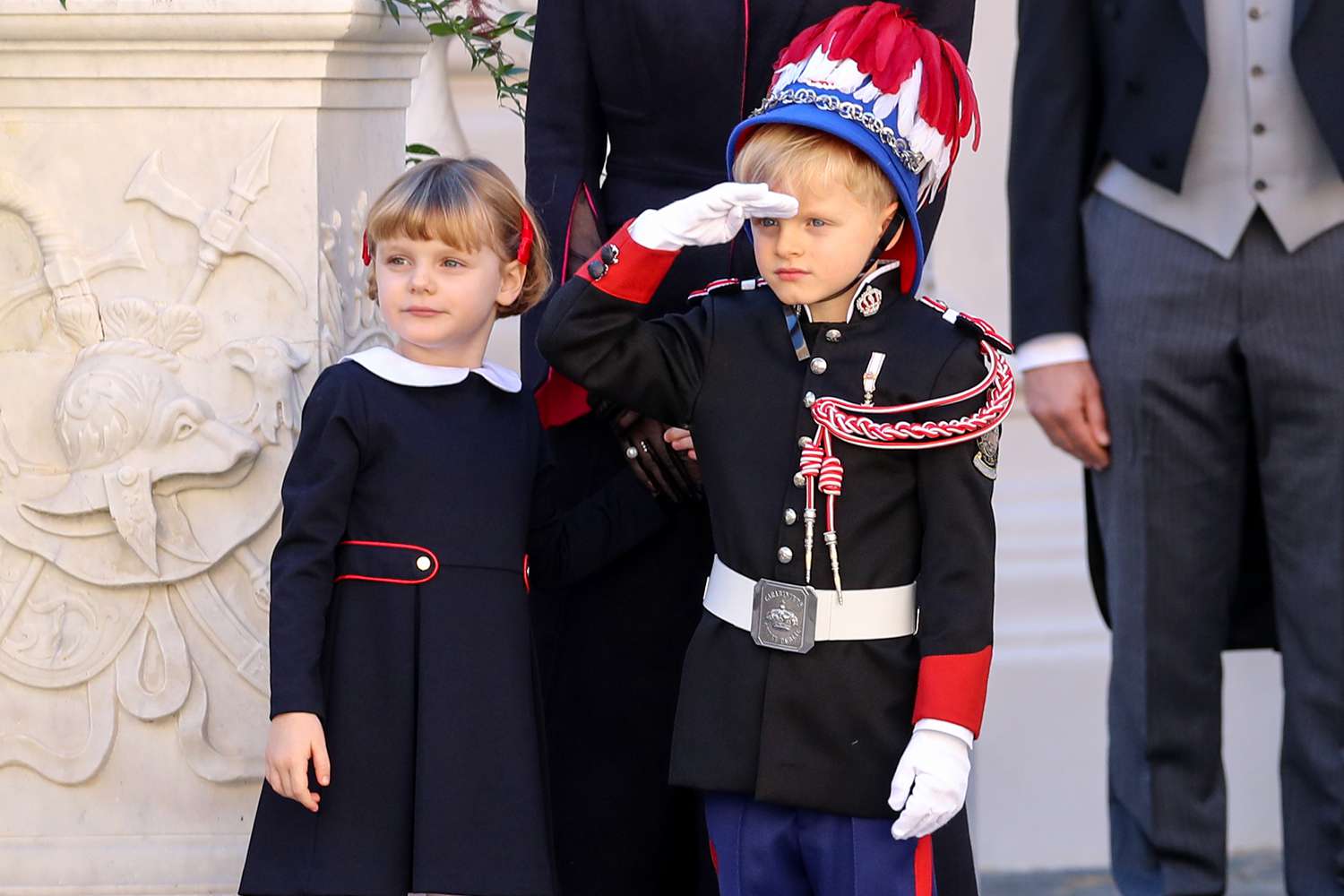 Prince Jacques of Monaco salutes next to Princess Gabriella of Monaco