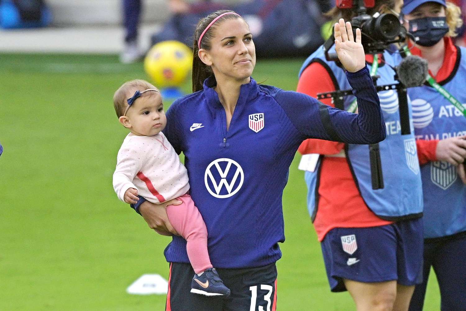 United States forward Alex Morgan (13) waves to fans in the stands while holding her daughter Charlie Elena Carrasco after a SheBelieves Cup women's soccer match against Brazil, in Orlando, Fla